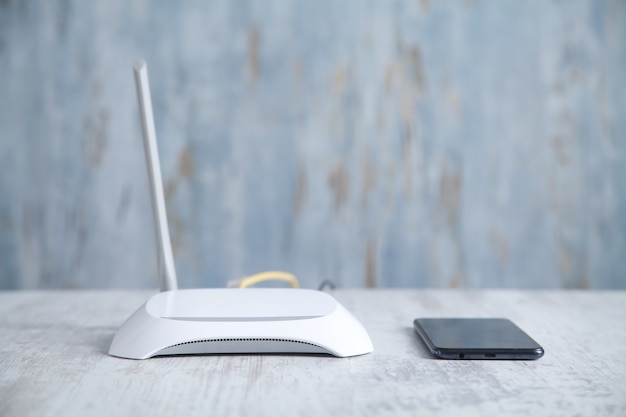 Router internet con smartphone sulla scrivania. rete, tecnologia