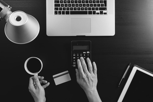 Internet shopping concept Top view of hands working with calculator and laptop and credit card