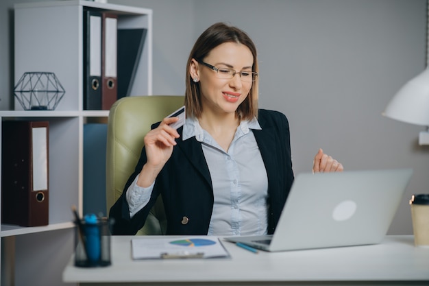 Internet winkelen afrekenen met creditcard betaling. Bedrijfsvrouw die online met Laptop in Bureau winkelen.