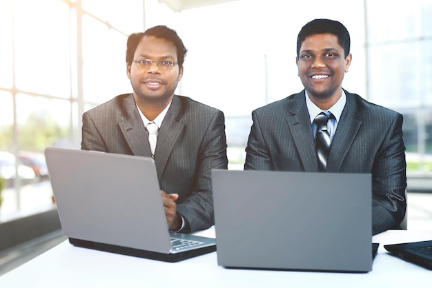 Photo interracial business team working at laptop in modern office