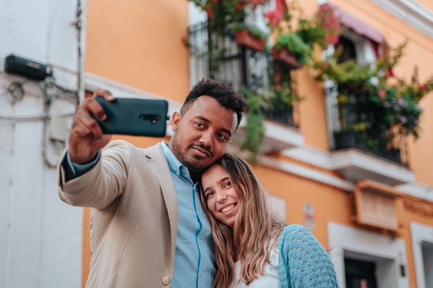 Interracial couple of an African American boy and a Caucasian girl taking a selfie while