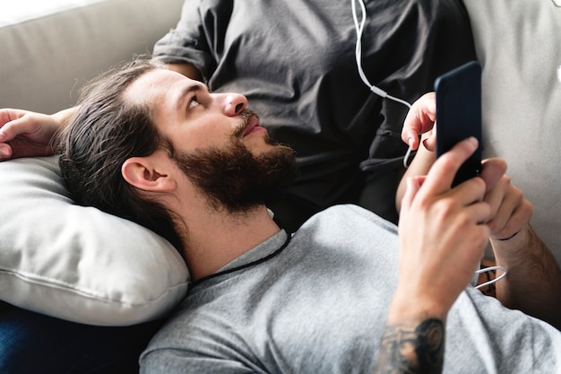 Interracial couple on a couch listening to music