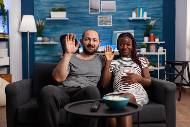 Happy Mixed Race Couple Relax On Couch In Living Room Watch Movie