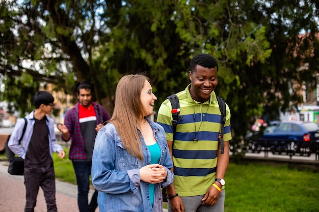 Interracial couple walking in park together with their friends