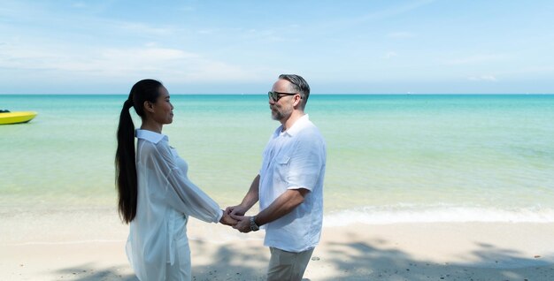 Interracial couple with the joy of traveling to the beautiful blue sea like the paradise