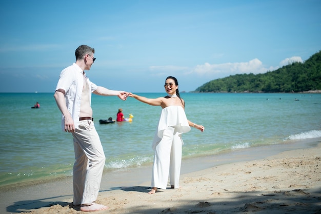 Interracial couple with the joy of traveling to the beautiful blue sea like the paradise