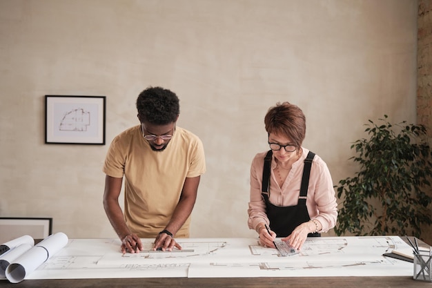 Interracial design architects examining building plan