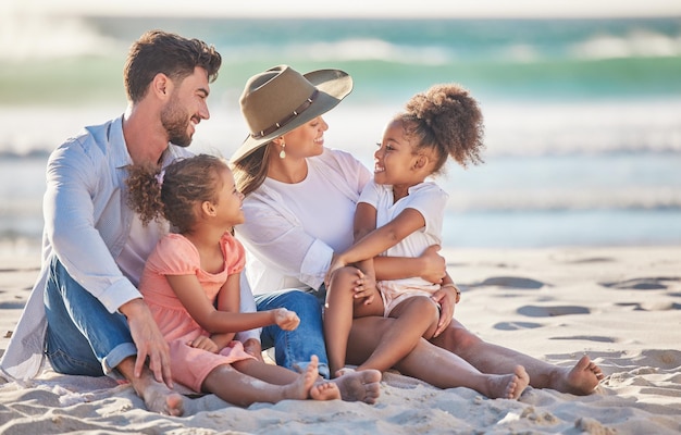 Interracial family beach vacation and travel with children and parents sitting in sand enjoying summer holiday in maldives Man woman and girl kids having fun and feeling happy on a tropical trip