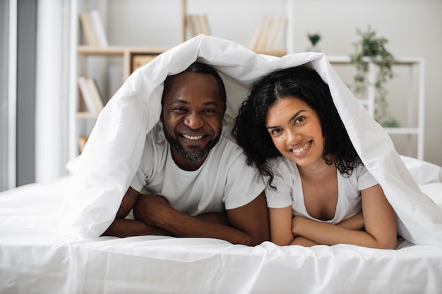 Interracial family lying together in bedroom