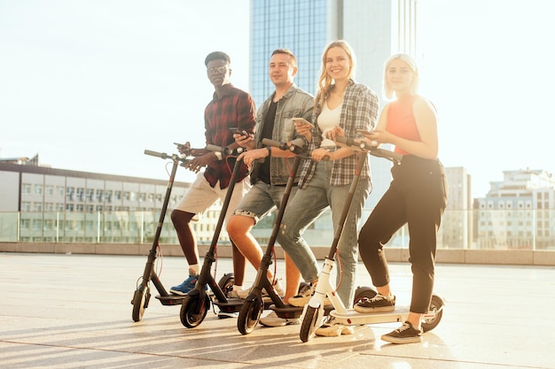 Interraciale vriendengroep huurt elektrische scooters met telefoons