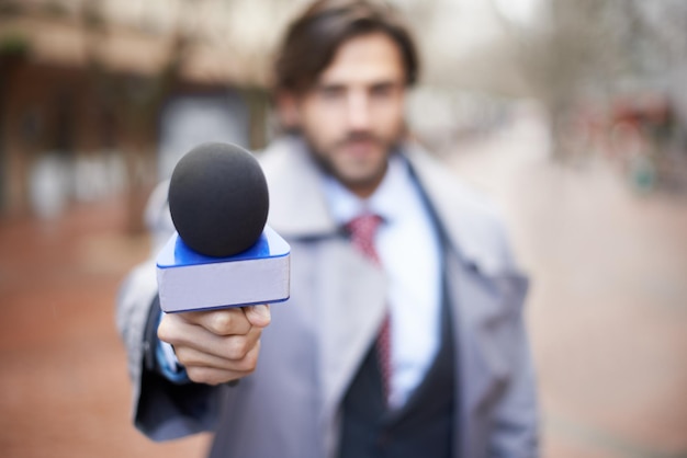 Photo interview man and hand with microphone for press news broadcast or question in the city tv journalist conversation and a male reporter with a mic for discussion interviewing and work in media