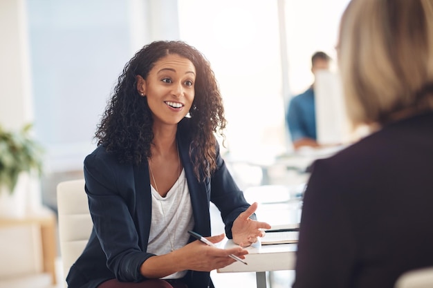Interview with a happy excited and confident human resources manager talking to a shortlist candidate for a job Young business woman meeting with a colleague or coworker in her office at work