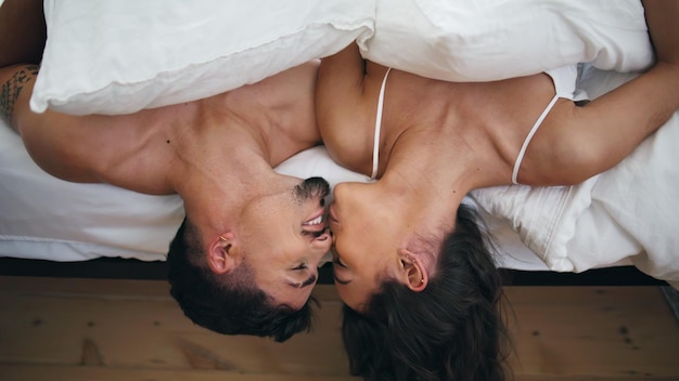 Foto amanti intimi che si baciano a letto, una coppia romantica che si rilassa in una stanza d'albergo.