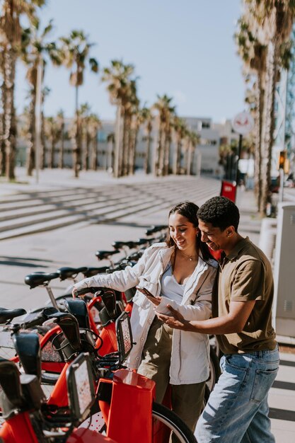 Intimate moment shared between a couple selecting public bicycles in sunny Barcelona