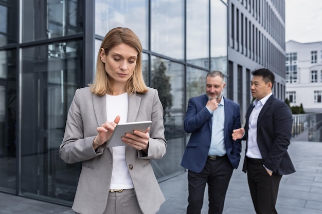 Intimidatie op werkgroep van zakenmensen buiten kantoorgebouw mannen bespreken achter vrouw