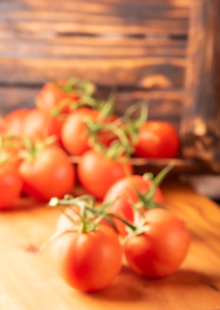 Intreepupil tomaten mooie details van verse rode tomaten op wijnstokken op rustiek hout wazig