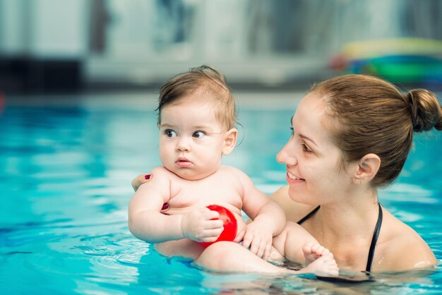 Introduction to water Baby and mother in swimming pool