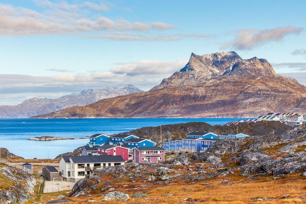 Inuit huizen en huisjes verspreid over het toendralandschap in een residentiële buitenwijk van de stad Nuuk met fjord en bergen op de achtergrond Groenland