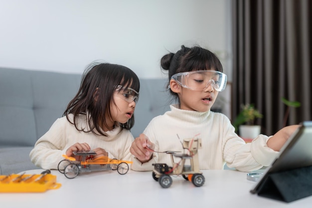 Photo inventive kid constructing robot cars at home