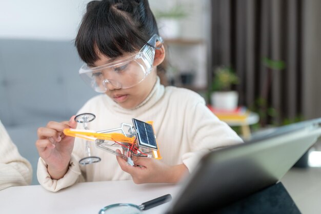 Inventive kid constructing robot cars at home