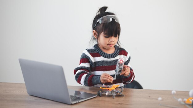 Inventive kid constructing robot cars at home