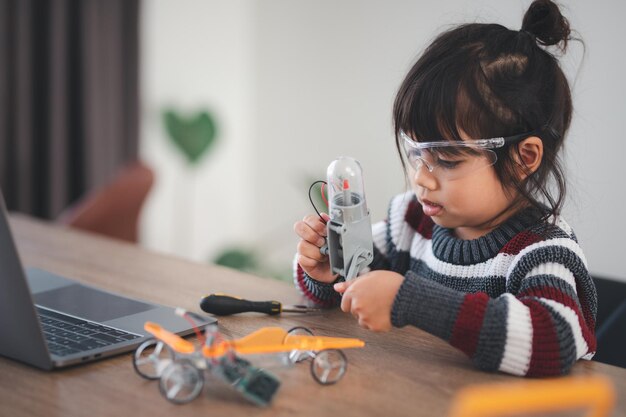 Inventive kid constructing robot cars at home