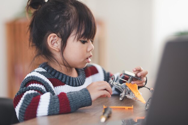 Inventive kid constructing robot cars at home