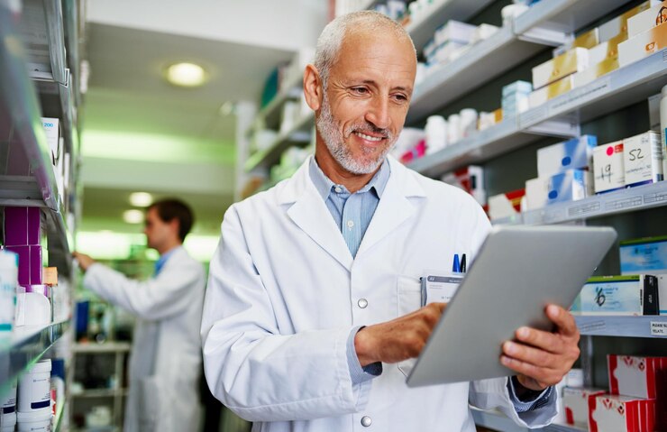 Photo inventory smile and tablet with pharmacist man checking stock of medicine on shelves for online order healthcare prescription and technology with happy mature chemist in medical pharmacy store