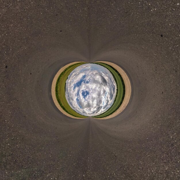 Photo inversion of blue little planet transformation of spherical panorama 360 degrees spherical abstract aerial view on road with awesome beautiful clouds curvature of space