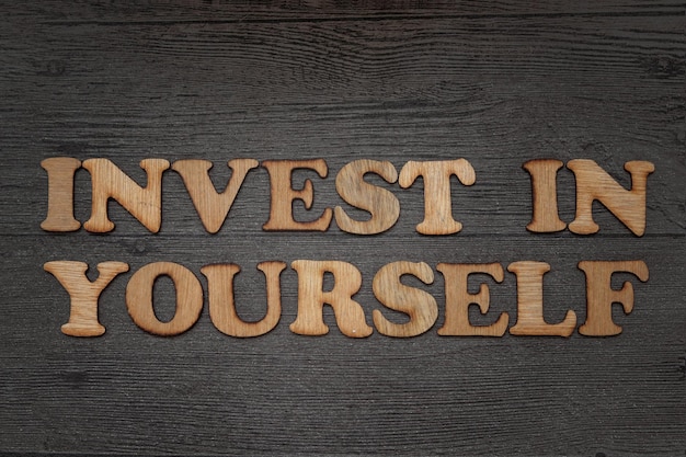 Invest In Yourself Business concept for Self Motivation text typography written on wooden alphabet