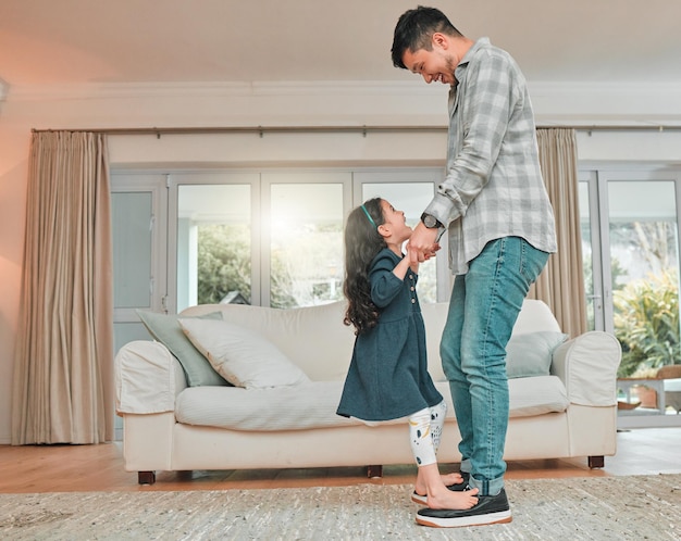 An invested dad is the greatest dad. Shot of a father practicing a dance routine with his daughter at home.