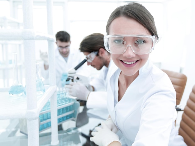 Investigator checking test tubes Woman wears protective goggles