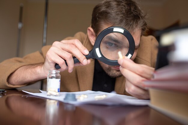 The investigator examines the evidence through a magnifying\
glass