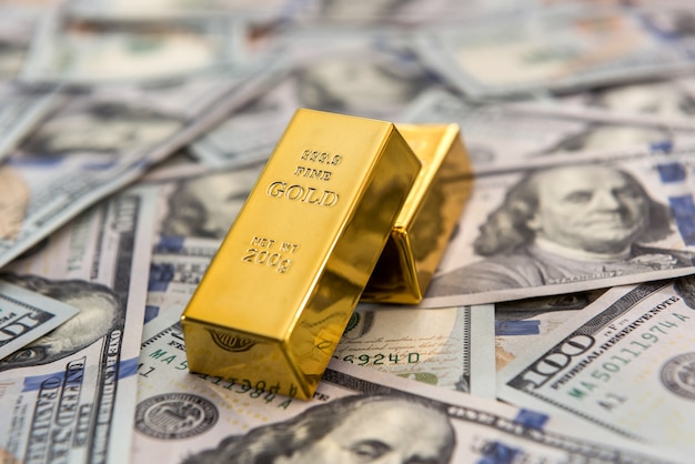 Investing in real gold bullion on dollar bills. money and save concept