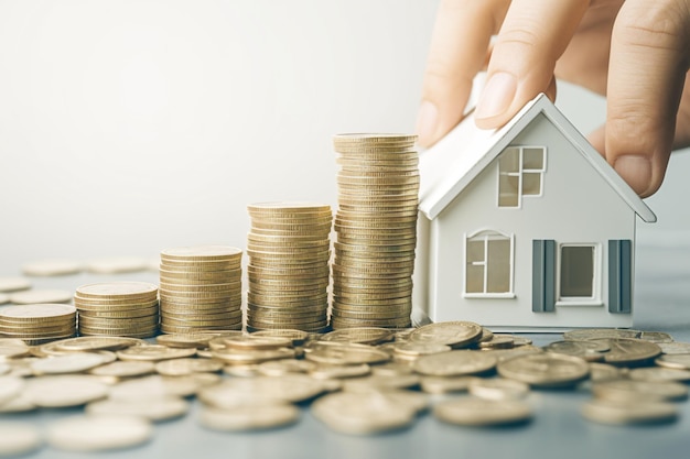 Investment strategy House model and coins for real estate savings