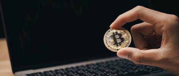 Investor Businessman holding a golden bitcoin on dark background, trading, Cryptocurrency.