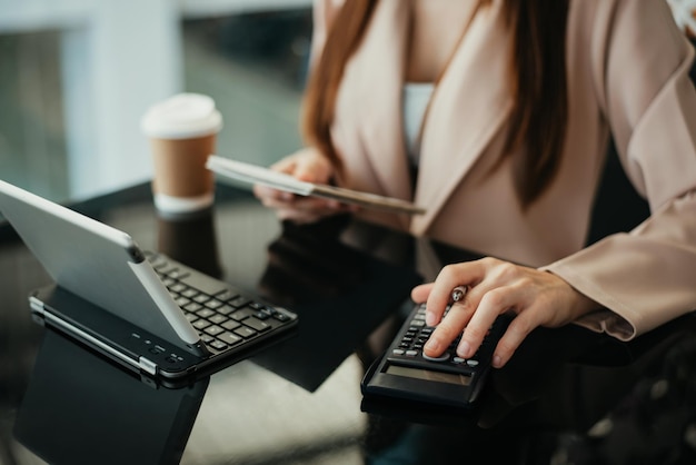 Gli investitori stanno calcolando sulla calcolatrice i costi di investimento e tenendo in mano il tablet