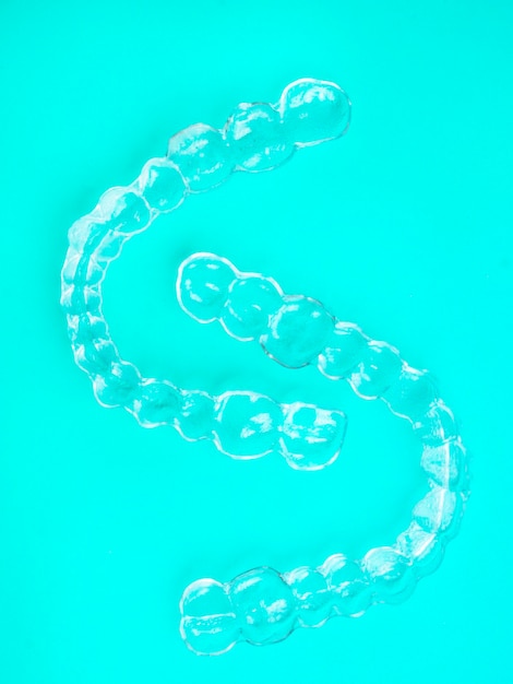 Invisible dental teeth brackets tooth aligners on blue background plastic braces dentistry retainers to straighten teeth Orthodontic temporary removable straighteners in dentist office dental