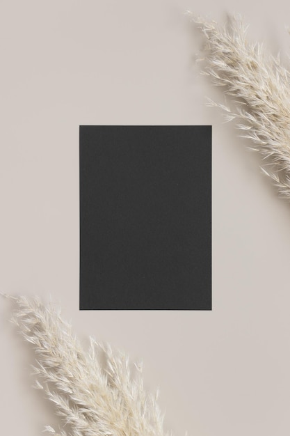 Foto mockup di carta nera di invito con una decorazione di erba pampas rapporto 5x7 simile a a6 a5