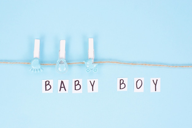 Photo invitation for shower party concept. top view photo of background with clothespins and inscription baby boy on it