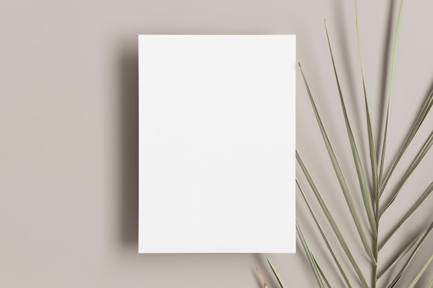 invitation white card mockup with a palm leaf on a beige table 5x7 ratio similar to a6 a5