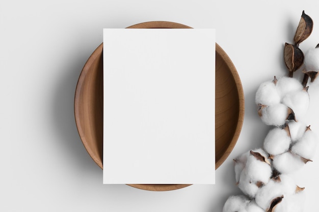 Invitation white card mockup on a wooden plate with a dried cotton branch 5x7 ratio similar to A6 A5