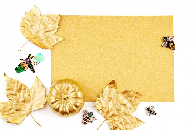 invitation with golden pumpkin and party objects, bats, overhead view