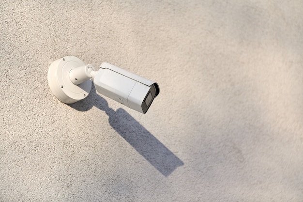 IP CCTV security camera on concrete wall background, cityscape