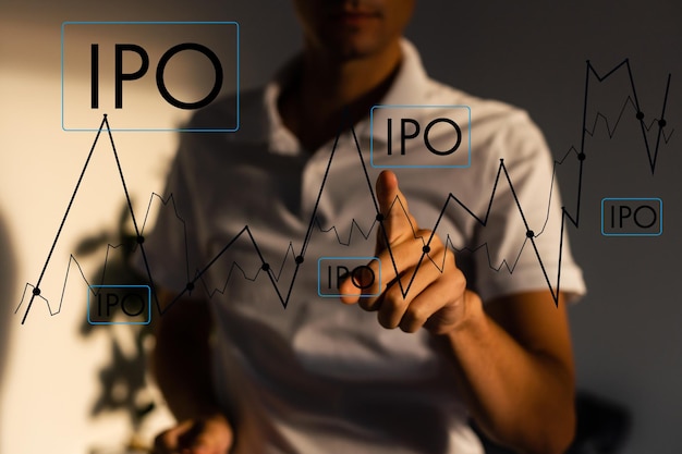 IPO - Initial Public Offering concept met hand indrukken van een knop op onscherpe abstracte achtergrond.