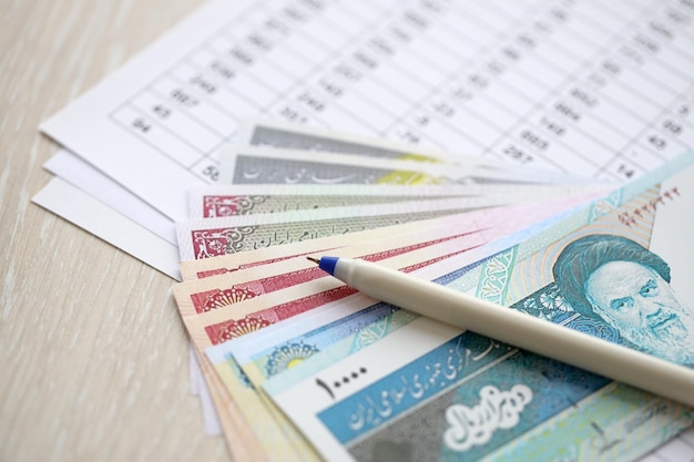 Iraanse zakelijke berekeningen op tafel met Iraanse geld en pen