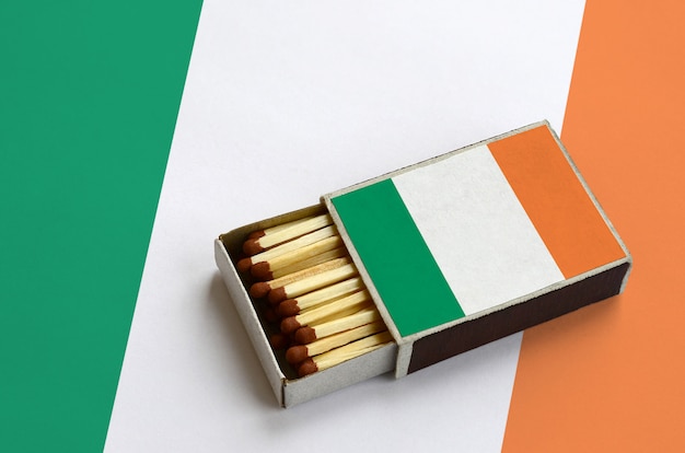 Ireland flag  is shown in an open matchbox, which is filled with matches and lies on a large flag