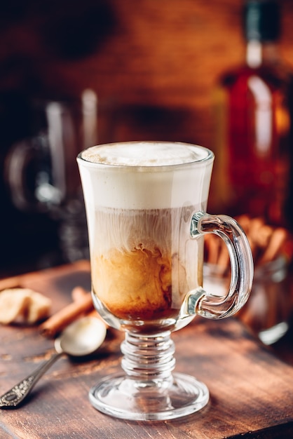 Irish coffee in drinkglas op houten ondergrond