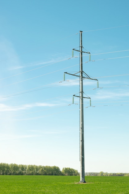 Iron bearing high voltage power lines on a green field.