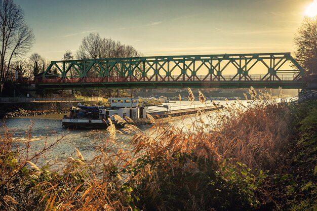 Foto ponte di ferro sul fiume contro il cielo durante il tramonto